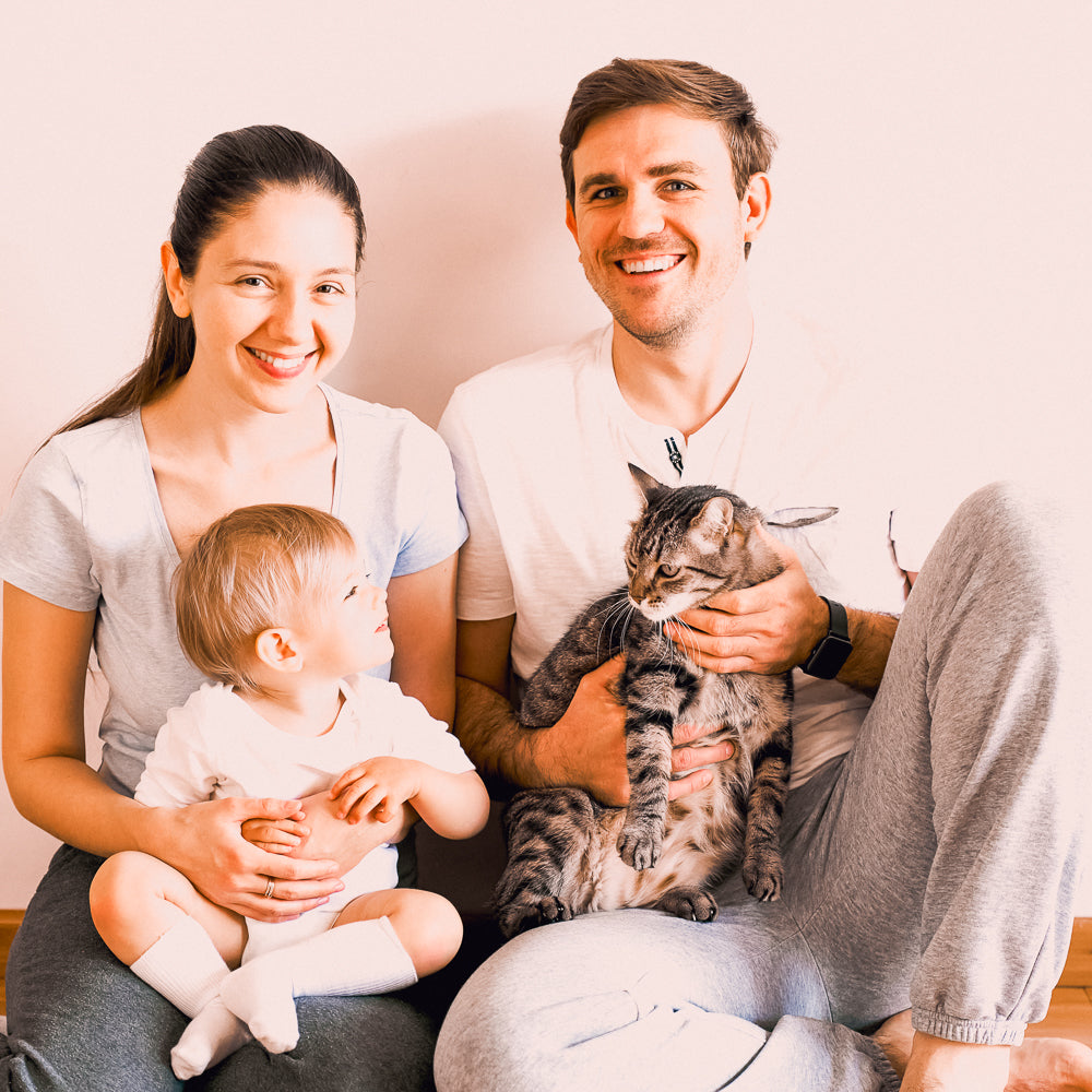 cat lady and cat dad family smile with cat and baby